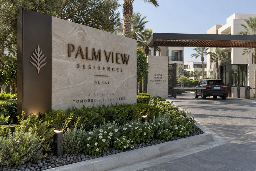 Residential entrance signage in Dubai: Stone monument sign with bronze letters and emblem